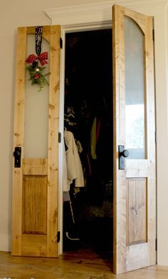 an open wooden door with clothes hanging on it