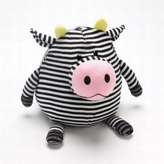 a black and white striped stuffed cow with horns on it's head sitting down