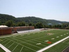 an empty football field with mountains in the background