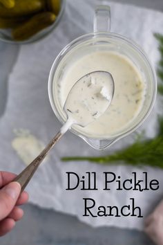 dill pickle ranch in a blender with a hand holding a spoon over it