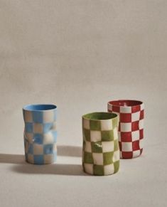 three different colored vases sitting next to each other