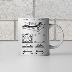 a white coffee mug with a drawing of a turntable on the front and side