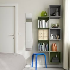 a bed room with a neatly made bed and bookshelves