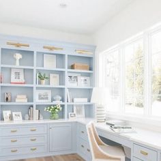 a home office with light blue cabinets and wood floors