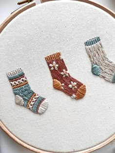 three pairs of socks are embroidered on a hoop