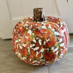 a painted pumpkin sitting on top of a wooden floor