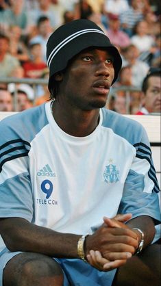 a man sitting on top of a bench in front of a crowd