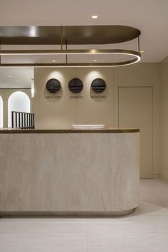 an empty reception area with three circular lights above the counter and round windows on the wall