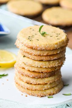 a stack of crackers sitting on top of a white plate next to lemon slices