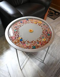 a white table topped with lots of confetti on top of a wooden floor