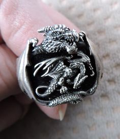 "Fabulous Dragon silver and onyx men's ring with hallmark \"© BGE 925\".  Fantasy dream of dragon with wings expanding over the sides.   Setting center features a rectangular onyx stone framed by a three-dimensional spread wing Dragon.  Both sides of the upper shank have detailed dragon wings' design.   Shank/band measures 5/8\" at the top and tapers down to 1/4\".   The setting measures 15/16 \" x 3/4\".   Excellent condition, but does have a small \"nick\" on the bottom of the shank and could use a polish. Perfect gift or to add to your sterling silver jewelry, men's statement ring, onyx jewelry. ~ WEIGHT: 22 g ~ MEASUREMENT: Size 12 ~ CONDITION: Excellent  ~ SIGNED: \"©BGE 925\" All of our items are sold in as is condition. Most of them are used unless otherwise stated. Please review al Dragon With Wings, Wings Ring, Colorful Mid Century Modern, Fantasy Dream, Onyx Jewelry, Dragon Wings, Wings Design, Large Man, Men's Ring