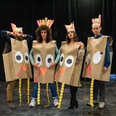 four people wearing paper bags with turkeys on them