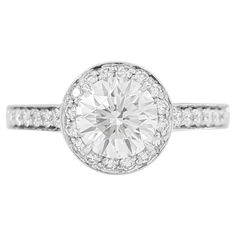 a white gold ring with an oval cut diamond in the center and pave set shoulders