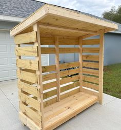 a small wooden shelter sitting on top of a cement floor next to a garage door