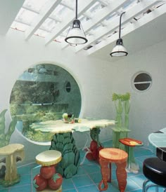 a room with many different colored tables and stools on the blue tile flooring