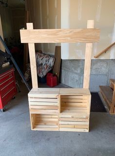 a wooden bench sitting in the middle of a garage next to a red toolbox