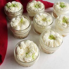 six small jars filled with white frosted desserts