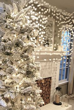 a white christmas tree in front of a fireplace