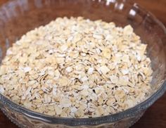 a glass bowl filled with oats on top of a wooden table