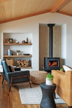 a living room filled with furniture and a fire place in the middle of it on top of a hard wood floor