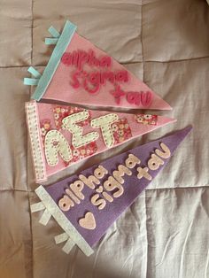 three kites that are on top of a bed with the words r ef and alphabet