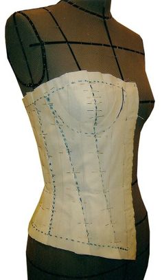 a woman's corset made out of white fabric with blue stitching