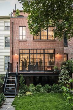 an apartment building with stairs leading up to the upper level and second story windows on one side