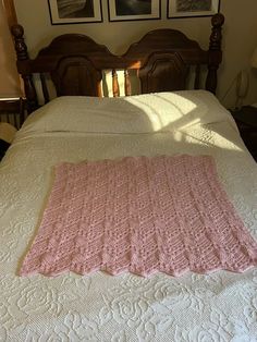 there is a pink crocheted blanket on the bed