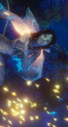 a woman is floating in the water surrounded by lights