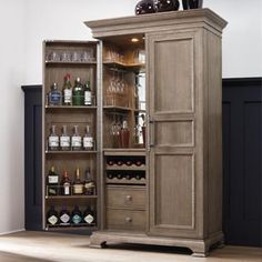 a tall wooden cabinet filled with lots of bottles