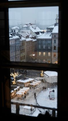 the view from an apartment window looking out onto a snowy city