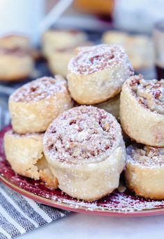 several cinnamon rolls on a plate with powdered sugar