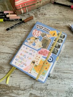 a notebook with stickers and pens on top of it next to some other items