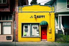 a yellow building with the words happy painted on it's front door and windows