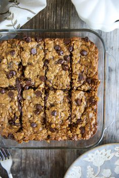 chocolate chip oatmeal cookie bars in a glass baking dish on top of a wooden table