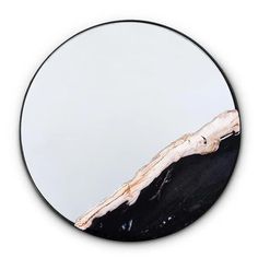 a round mirror with a piece of wood in the middle and a white background behind it