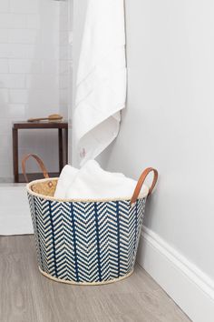 a white towel is sitting in a basket on the floor