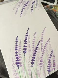 a painting of purple flowers on a white paper with watercolor pencils in the background