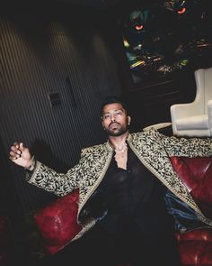 a man sitting on top of a red couch