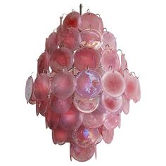 a chandelier made out of pink glass ornaments on a metal rod and hanging from the ceiling