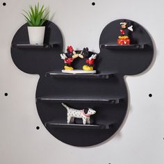 the mickey mouse shelf has two small figurines on it