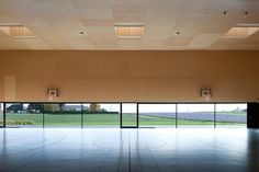 an empty room with large windows and basketball hoops on the wall in front of it