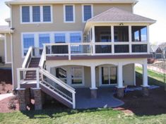 a two story house with stairs leading up to the upper floor and second level balcony