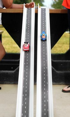 two children playing with toy cars on a track