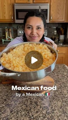 a woman holding a large pan filled with food