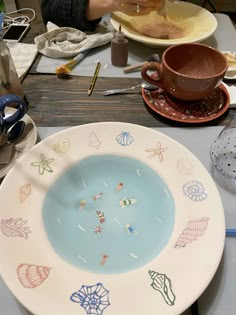 there is a plate that has been decorated with different designs on it, along with other plates and utensils