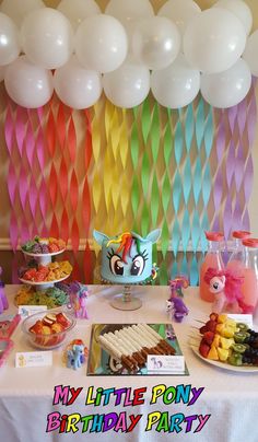 a table topped with lots of food and balloons