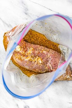 a piece of meat in a plastic bag on top of some bread and seasoning