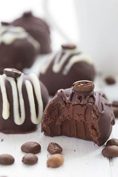 chocolate truffles with white frosting and nuts scattered around them on a table