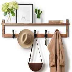 a hat, coat and purse hanging on a wooden shelf above a coat rack with hooks